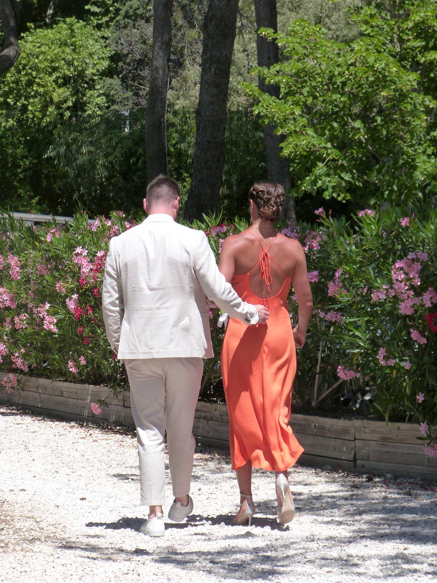 Chic couple walking in front of the laurels