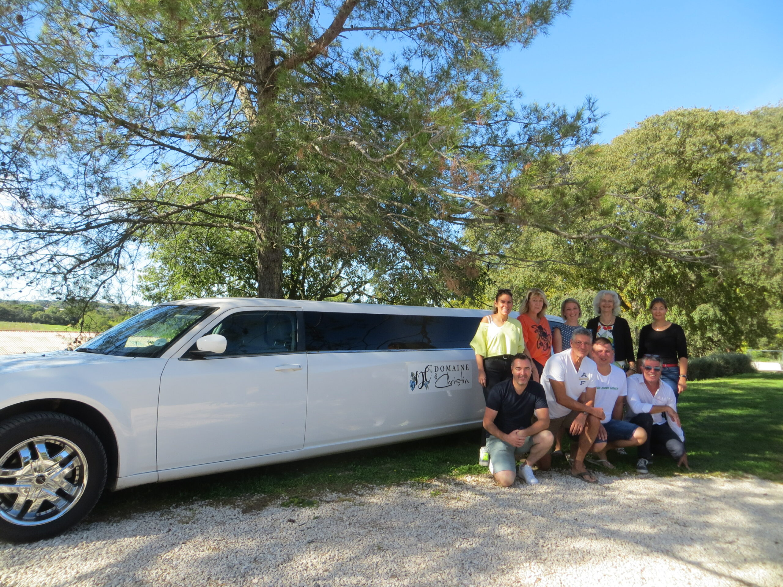People posing in front of a limousine