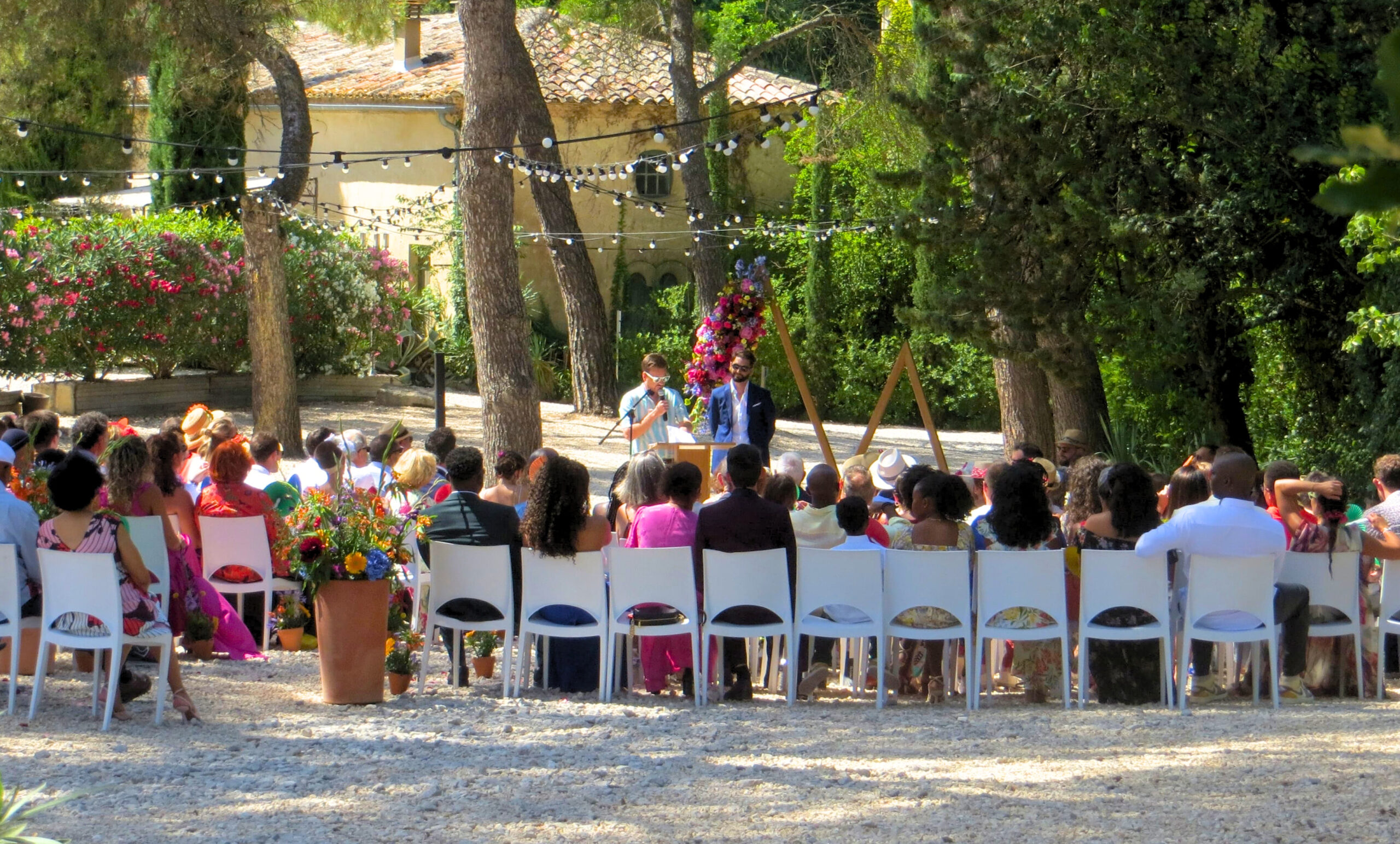 Guests sitting during a secular ceremony under the pines - L'ombrière